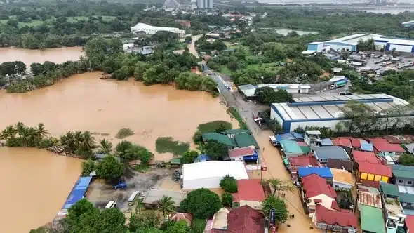 Floodwater surrounding a bridge and tropical community